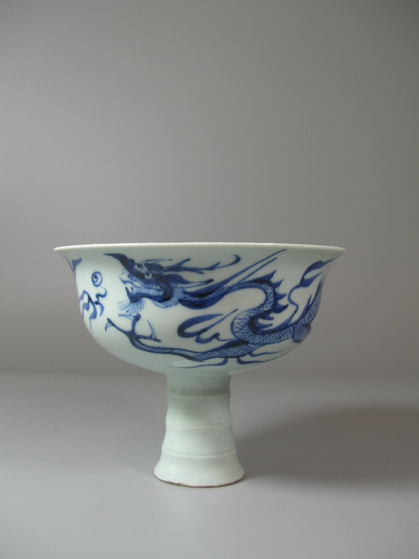 Fine Yuan-Style Blue and White 'Dragon' Stem Bowl: The exterior decorated with dragon motif, and the interior decorated with leaf-lappets in Anhua style and Buddhist thunder-bolt cross, after Yuan style, good condition, 4 3/8 in. (11 cm) high