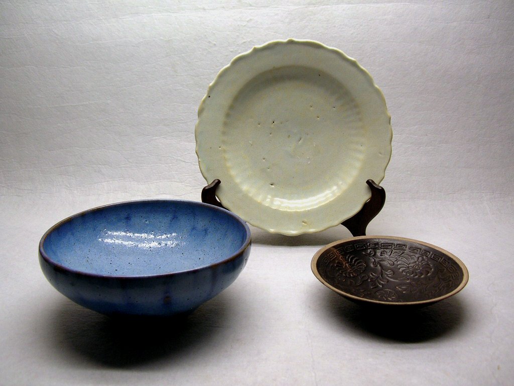 Two Bowls and a Plate Yuan or Ming #la025rg: Including a Junyao bowl, a Jizhou Ware bowl decorated with incised motifs, and a white glazed barbed-rim plate, Yuan or Ming dynasty, normal glaze wear, good condition, 5", 6 3/8", 7 5/8" wide, wooden