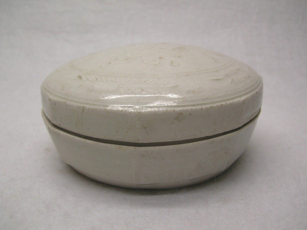 Chinese White Glazed Porcelain Box Song Dy. #la148c: A Chinese white glazed octagonal porcelain box and cover decorated with floriated motifs, a kiln adhesion to the cover, aged glaze wear, overall in good condition, Song or Ming dynasty, 4 1/4" wide