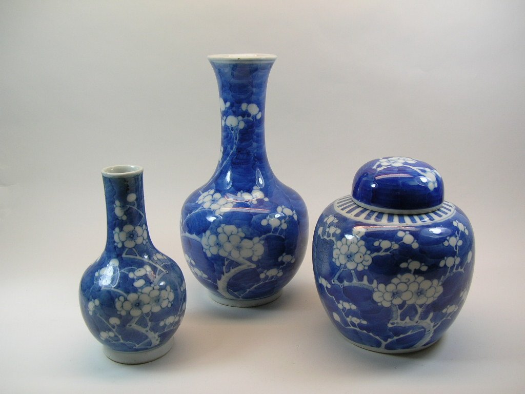 Two Chinese Blue and White Bottle Vase and a Jar: Late Qing Dynasty, all three items decorated with prunus motifs, the tall bottle vase and the jar each bearing a double-ring mark, the smaller one with an apocryphal Kangxi mark; in overall good condi