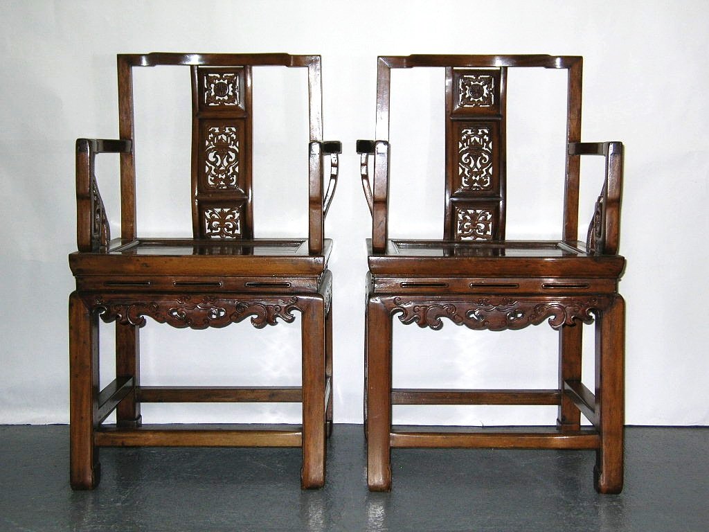 Very Fine Pair of Antique Chinese Nanmu Armchairs: A pair of Chinese Nanmu armchairs each finely carved with auspicious scroll motifs on front and side aprons, and openwork bat, dragon and bat patterns on the back 19th century, in overall good conditi