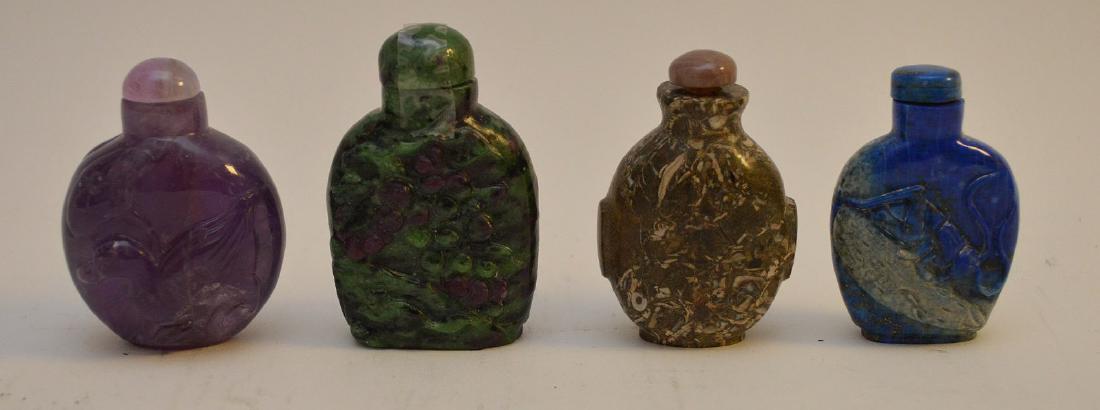 FOUR CHINESE SEMI-PRECIOUS STONE SNUFF BOTTLES -: FOUR CHINESE SEMI-PRECIOUS STONE SNUFF BOTTLES - Includes: a carved amethyst bottle with bird decoration 2 1/4" H; a brown stone * 2 1/2" H; a green and purple opaque snuff bottle 2 3/4" H; a lapis la