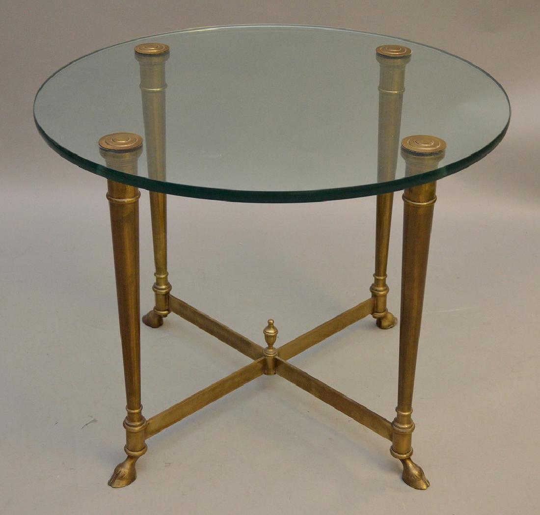 MCM circular side table, brass with glass top and hoof: MCM circular side table, brass with glass top and hoof feet, 20 inches tall x 26 inch diameter