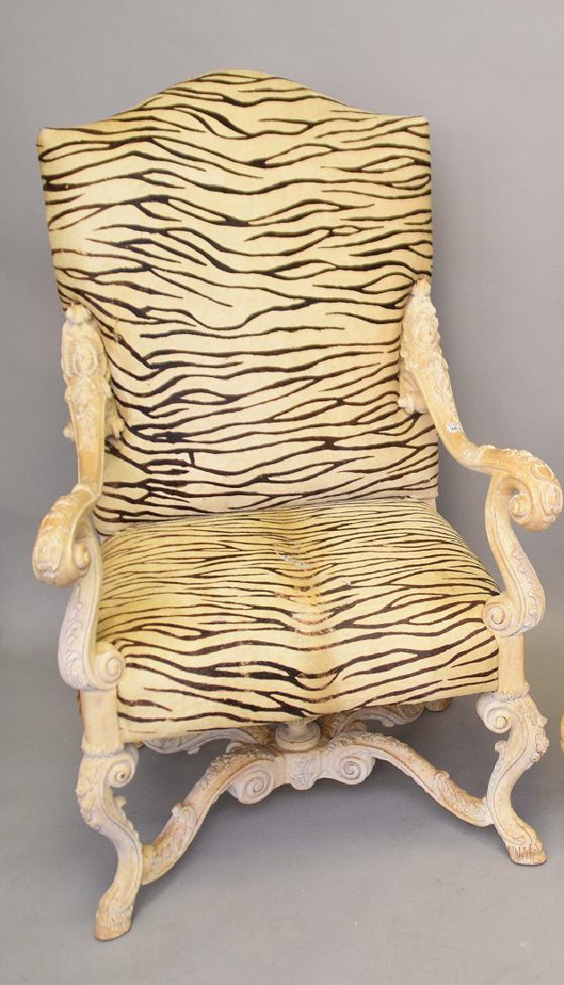 Heavily carved elaborate arm chair with masks on arms,: Heavily carved elaborate arm chair with masks on arms, matching above upholstery, ending in hoof feet (worn)