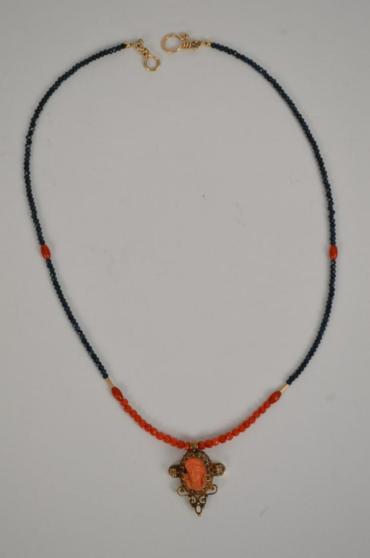 CORAL & 10K ROSE GOLD NECKLACE WITH CARVED CORAL CAMEO.: CORAL & 10K ROSE GOLD NECKLACE WITH CARVED VICTORIAN CORAL CAMEO PENDANT with faceted Sapphires. Necklace length 20” cameo height 1 1/4” total weight 12.9 grams.