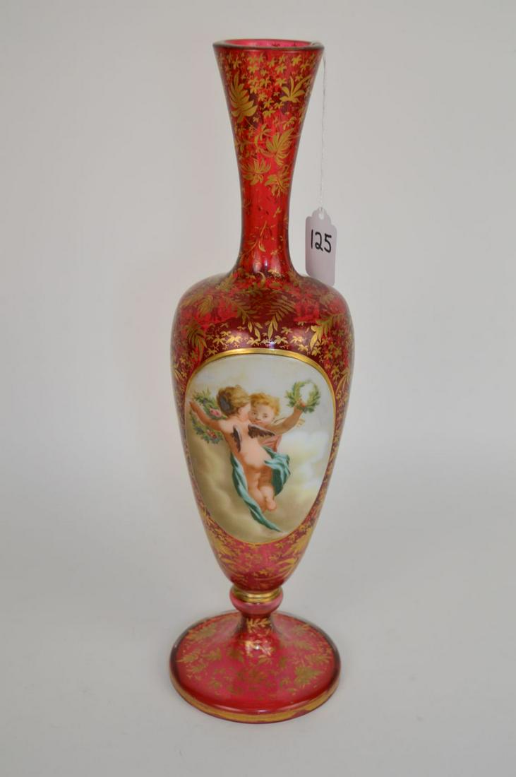 A BOHEMIAN CRANBERRY AND HAND PAINTED PORTRAIT GLASS: A BOHEMIAN CRANBERRY AND HAND PAINTED PORTRAIT GLASS VASE, LATE 19TH CENTURY. With hand painted portrait of a cherubs on white opal medallion front. The back with a painted floral scene on white opal 