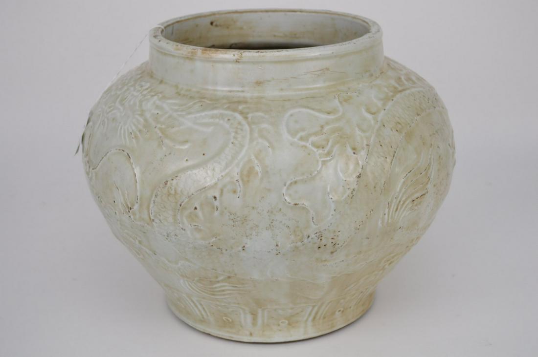 CHINESE QING DYNASTY CARVED BLANC DE CHINE PORCELAIN: CHINESE QING DYNASTY CARVED BLANC DE CHINE PORCELAIN JAR with continuous dragon scene. Condition: old staple repair. Height 11 1/2" Diameter 14 1/4"
