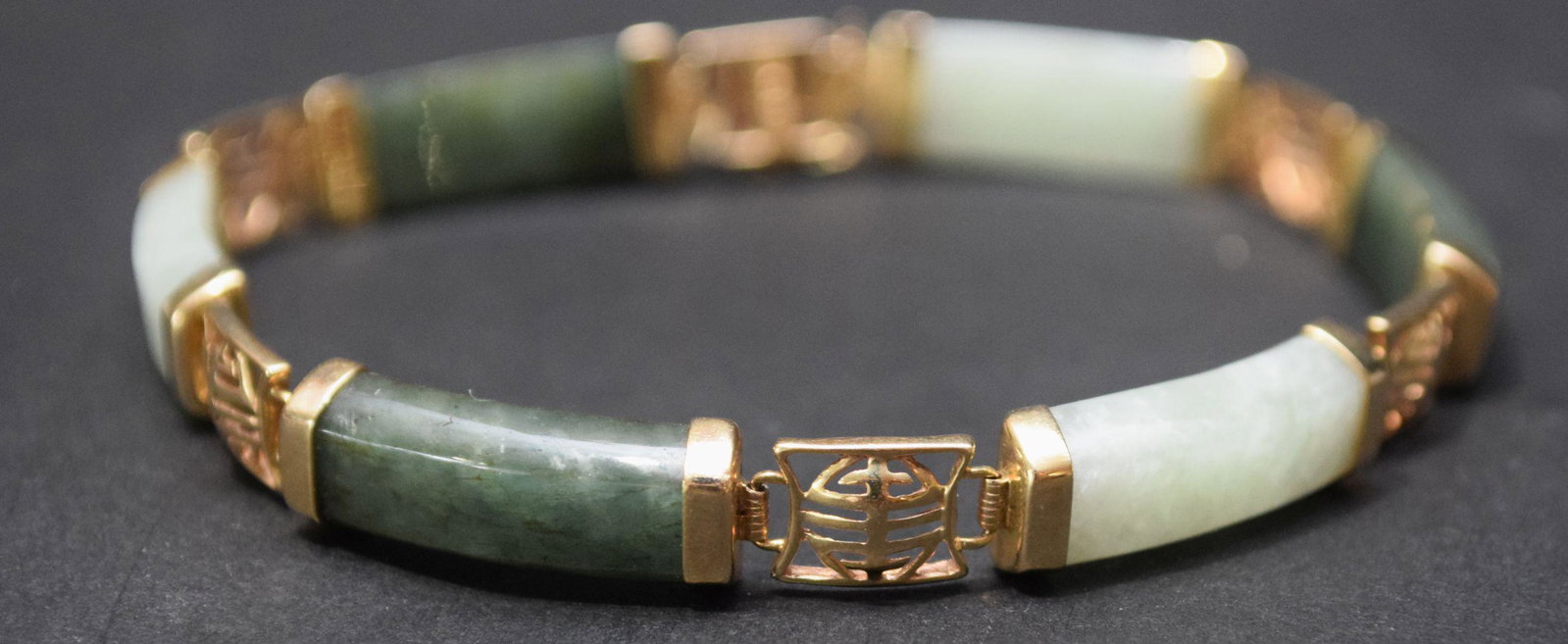 14K Yellow Gold Jade Bracelet. Light and dark green: 14K Yellow Gold Jade Bracelet. Light and dark green jade Size 7", weight 12.4 grams. Condition good normal wear