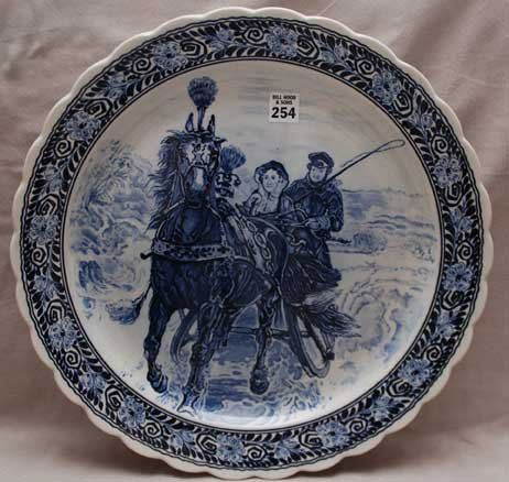 Blue and white charger, couple in horse drawn sled: Blue and white charger, couple in horse drawn sled, lion at center on back, 16"dia