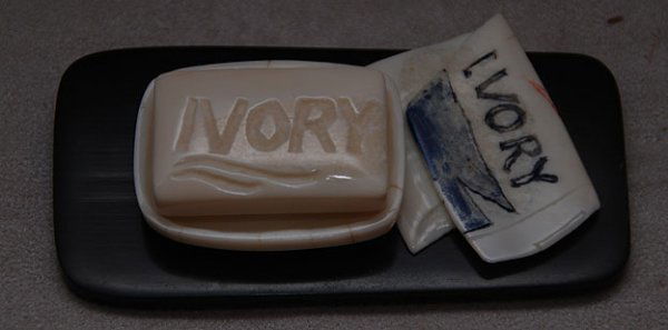 Alaskan ivory bar of soap in soap dish, "Ivory" a: Alaskan ivory bar of soap in soap dish, "Ivory" as in ivory soap, carved into the soap piece, 4 age cracks, 1 3/4"l x 1/2"h