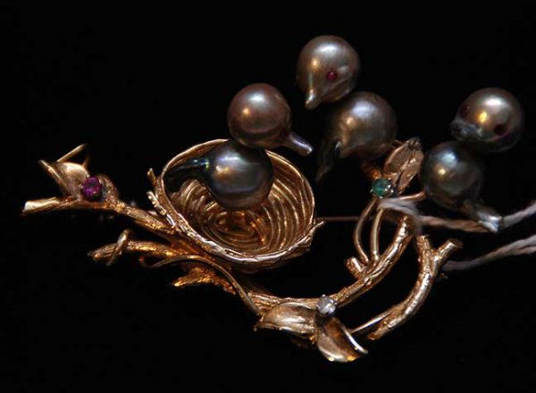 Brooch, 14k yellow gold, the brooch is a tree bran: Brooch, 14k yellow gold, the brooch is a tree branch set with one ruby accent, 1 sapphire accent and 1 emerald accent, the tree branch is holding a bird's nest and 3 birds, each having 2 natural grey