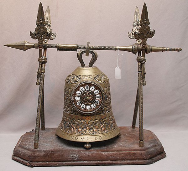 Heavy bronze/ormulu embossed clock in the form of : Heavy bronze/ormulu embossed clock in the form of a bell suspended on ecclesiastical cross bars mounted on very worn velvet platform