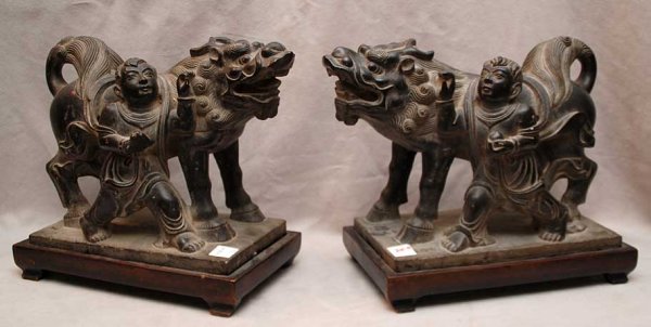 Pair of carved stone mythological animals with ha: Pair of carved stone mythological animals with handler at side on affixed wood stands, animals are 13"L x 9 1/2"h x 6"w
