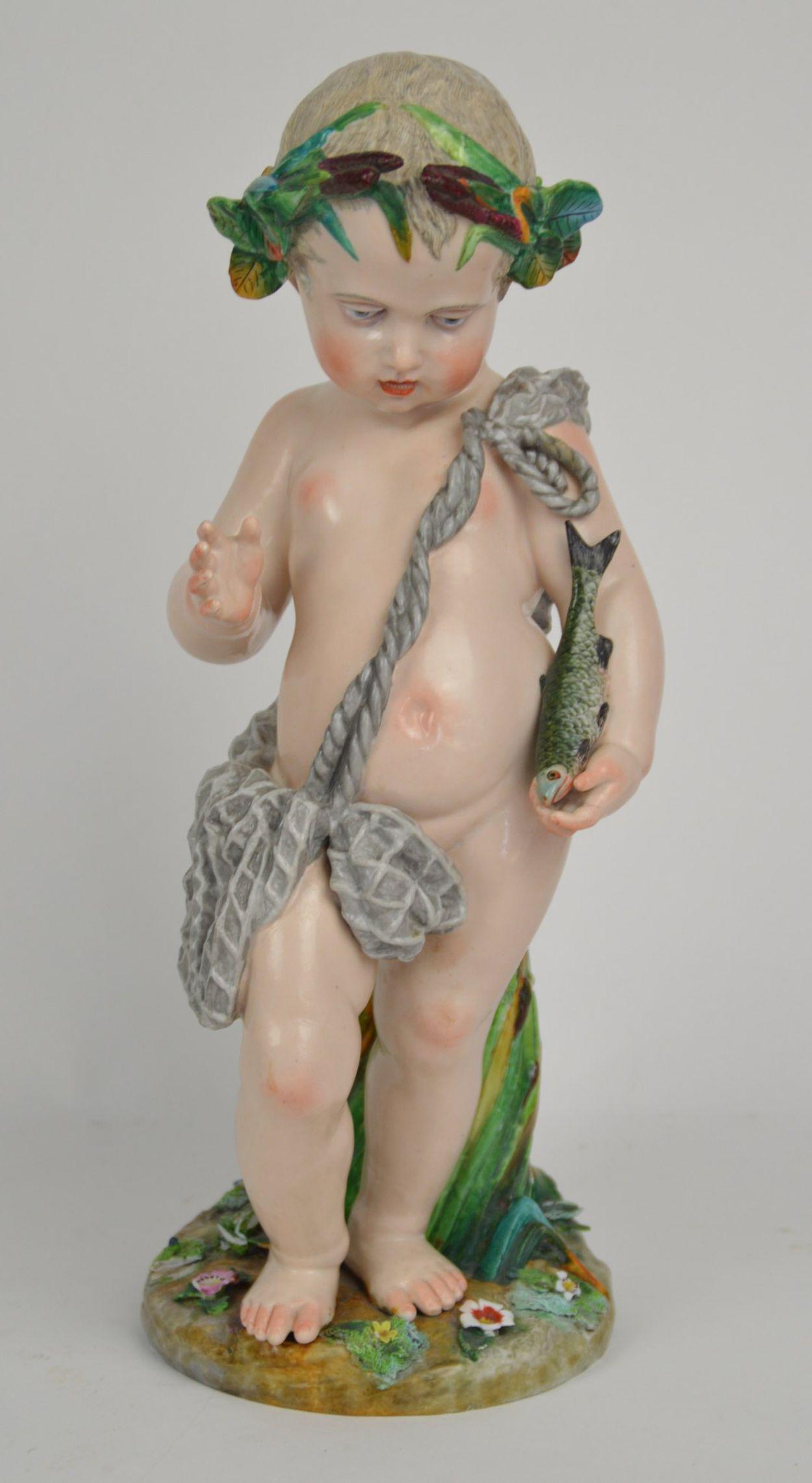 German Porcelain Putto with Fish Figure - Well formed: German Porcelain Putto with Fish Figure - Well formed porcelain figure of a child holding a fish with a foliate crown and rock back support. Applique flowers and foliage on base. 17 1/2" H. Condition: