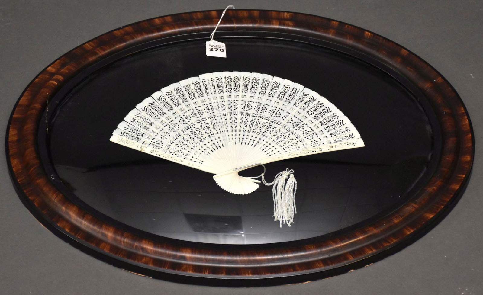Framed Antique Carved Bone Fan - Reticulated design on: Framed Antique Carved Bone Fan - Reticulated design on fan, professionally mounted and framed in an oval frame. Overall framed - 33 1/4" L x 17" H. Condition: Minor normal wear.