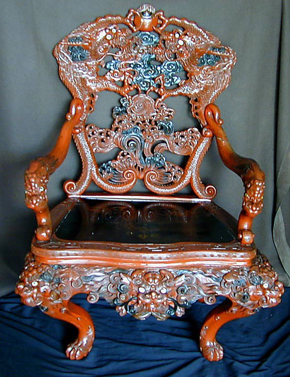 ANTIQUE CHINESE CARVED RED LACQUER DRAGON CHAIR A: ANTIQUE CHINESE CARVED RED LACQUER DRAGON CHAIR A dramatically carved armchair with red lacquer dragons; the dragon eyes inlaid mother-of pearl; sinuous curved dragon arms & legs, black lacquered deco