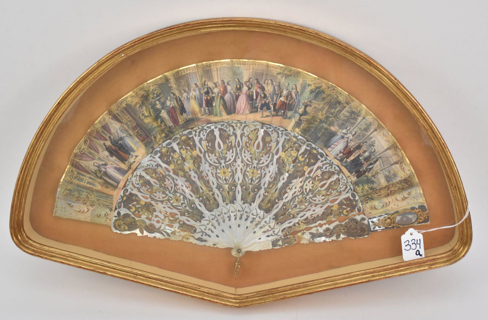 Framed Antique Mother of Pearl Fan - A folding fan with: Framed Antique Mother of Pearl Fan - A folding fan with reticulated and gilt mother of pearl sticks, gilt metal and mirror outside stick, and a paper scene featuring a scene of formal dressed people a