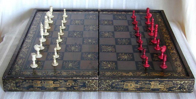 MID 19THC CHINESE EXPORT BOXED CHESS SETA lacquere: MID 19THC CHINESE EXPORT BOXED CHESS SETA lacquered case for chess and backgammon, comprising dyed red & natural color carved ivory backgammon discs and carved bone chess pieces, missing 4 backgammon