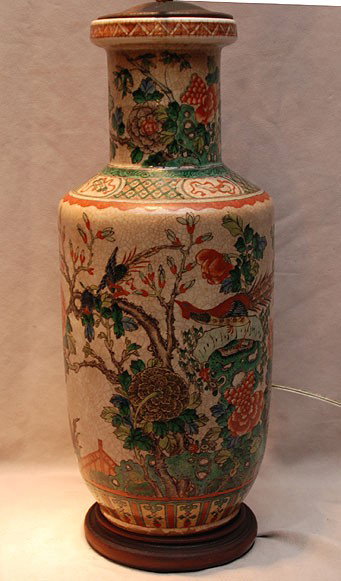 Ceramic jug shape table lamp with painted oriental: Ceramic jug shape table lamp with painted oriental motif of symbolic flowers, exotic birds and floral sprays in colors of orange, green, vermilion, blue and grey on circular wooden base, contemporary,