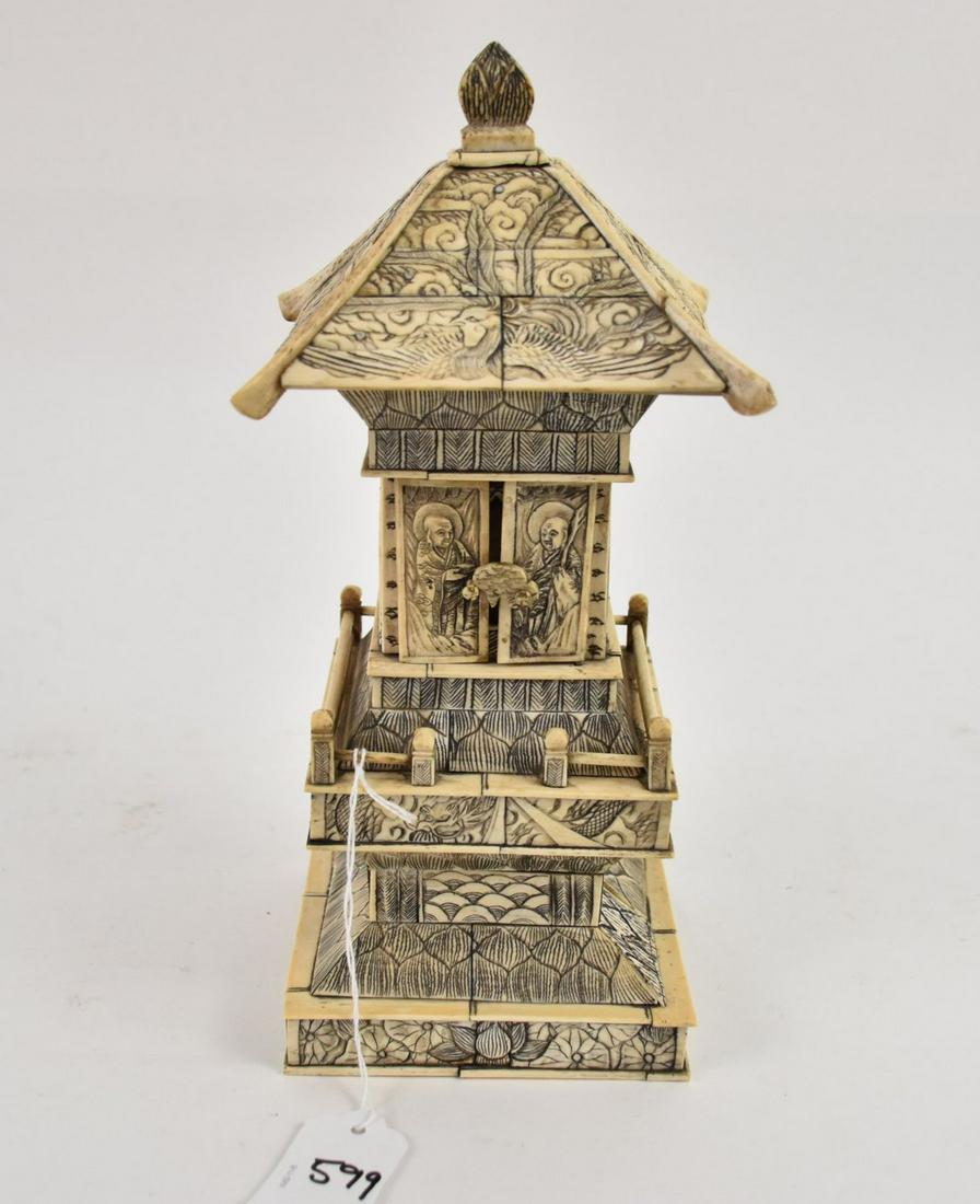 Vintage Chinese Carved Relief Bone Buddhist Temple - A hand carved bone veneer sculpture of a temple: Vintage Chinese Carved Relief Bone Buddhist Temple - A hand carved bone veneer sculpture of a temple building. The surface has ornate relief carving. Two doors open at front to reveal a meditating Bud