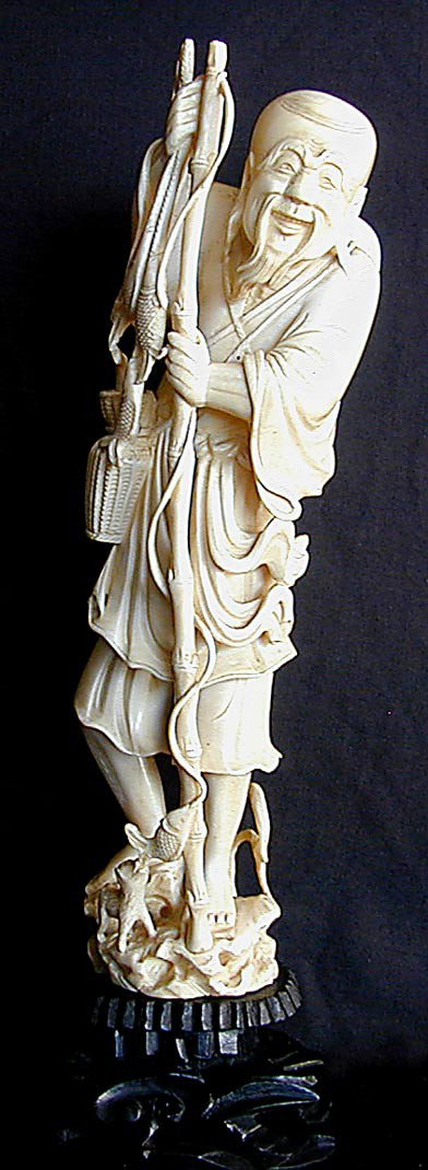 OLD CHINESE IVORY FISHERMAN CARVING A finely carve: OLD CHINESE IVORY FISHERMAN CARVING A finely carved and highly detailed figural carving of a smiling and bearded Chinese man holding his bamboo fishing rod and baskets full of fish, at the base is a s