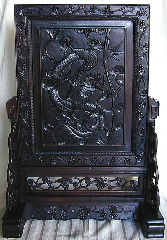 LARGE CHINESE WOOD DRAGON SCREEN A large vintage C: LARGE CHINESE WOOD DRAGON SCREEN A large vintage Chinese wood table screen with a carved dragon motif in the center panel, the frame and base of the screen is carved with an all over floral and berry