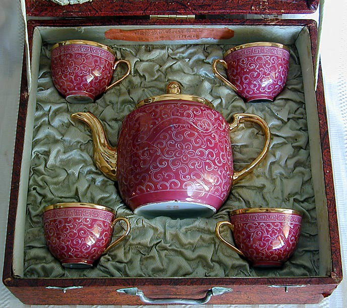 BOXED CHINESE PORCELAIN TEA SET A boxed set of 4 c: BOXED CHINESE PORCELAIN TEA SET A boxed set of 4 cups and teapot in a purple and gilt enamel design, teapot measures 6"H, teacups each measure 2.25"H, all pieces in very good condition.