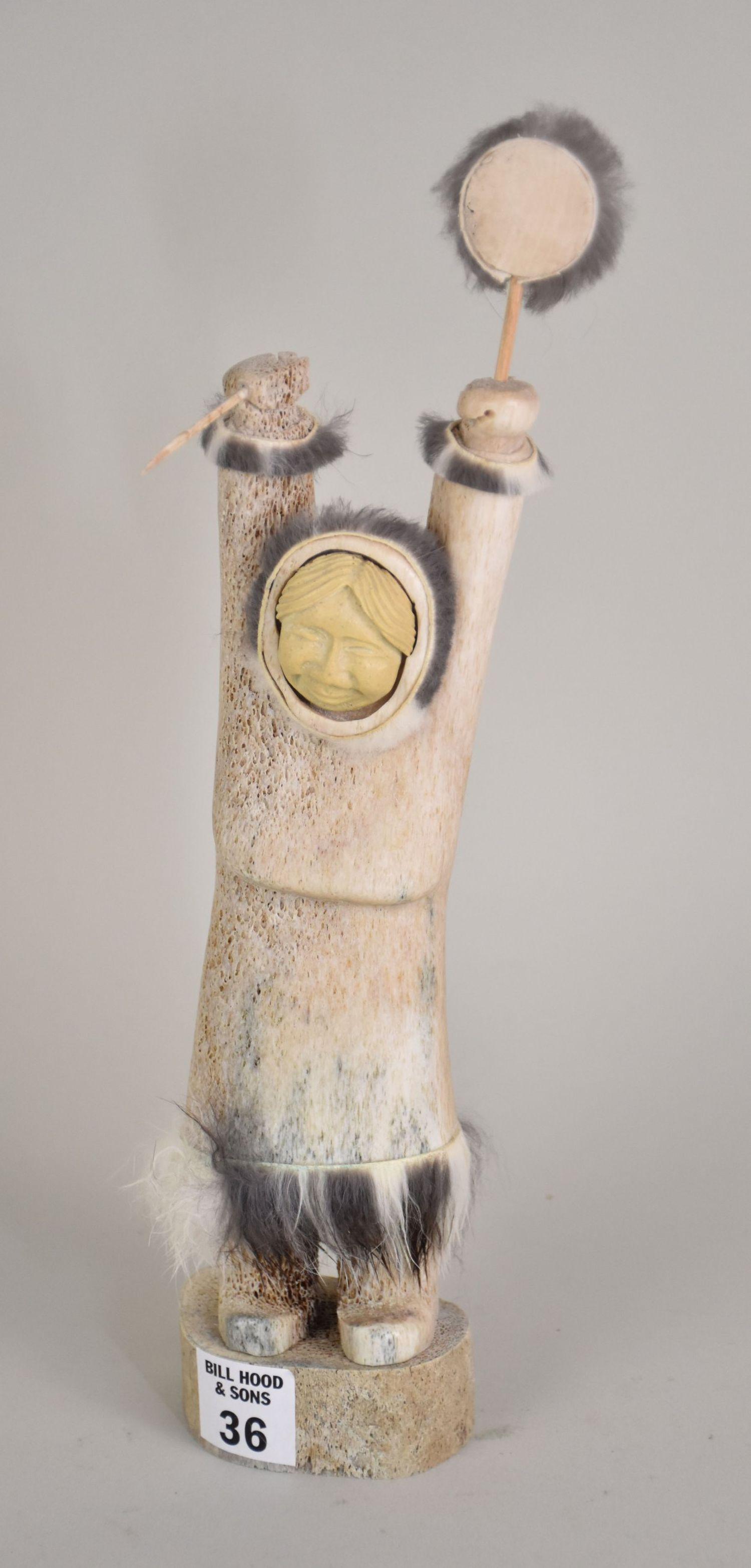 Vintage tall Inuit bone carved figure. Depicting a huntress holding a harpoon and a drum in middle: Vintage tall Inuit bone carved figure. Depicting a huntress holding a harpoon and a drum in middle of a hunt. Finely detailed and signed underneath. Good condition. 12” tall x3” wide