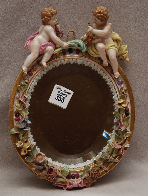 Meissen framed mirror with 2 puttis, 9 1/2"h (flow: Meissen framed mirror with 2 puttis, 9 1/2"h (flowers chipped and puttis wings are broken)
