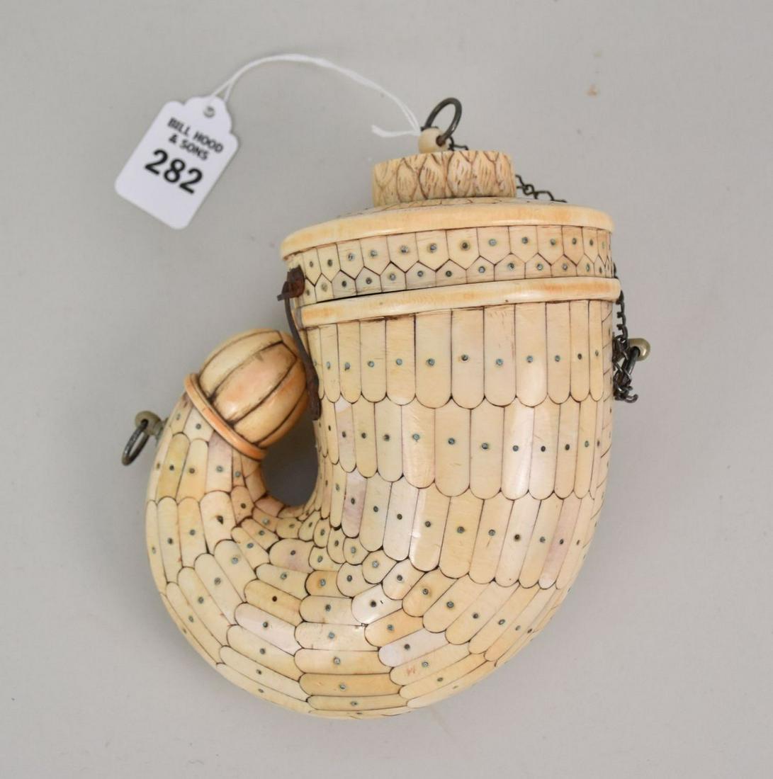 Antique Mughal Indian Powder Flask of Bone - c. 19th century, India. A wooden powder horn in the: Antique Mughal Indian Powder Flask of Bone - c. 19th century, India. A wooden powder horn in the shape of a nautilus, covered in a mosaic-style pattern of bone fragments. The interior of the flask is