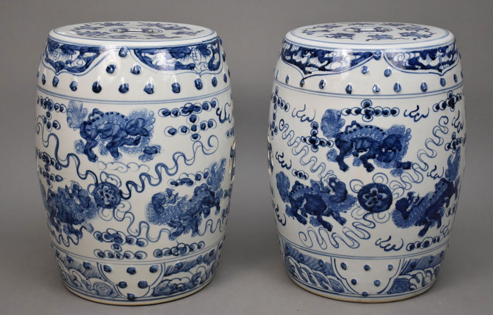 Pair Chinese Blue & White Porcelain Garden Stools - Blue underglaze decoration featuring foo dogs: Pair Chinese Blue & White Porcelain Garden Stools - Blue underglaze decoration featuring foo dogs and sacred objects motifs, pierced medallions. 18 1/2" h x 13" w.