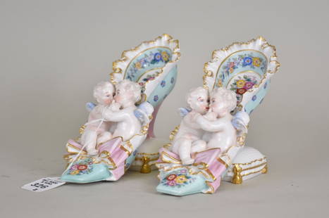 Pair Meissen German Porcelain Cherubs in Shoe Figures - Two Meissen porcelain Shoe figurines. Each: Pair Meissen German Porcelain Cherubs in Shoe Figures - Two Meissen porcelain Shoe figurines. Each shoe is an ornately decorated 18th century-style shoe with the heel resting upon a pillow and two che