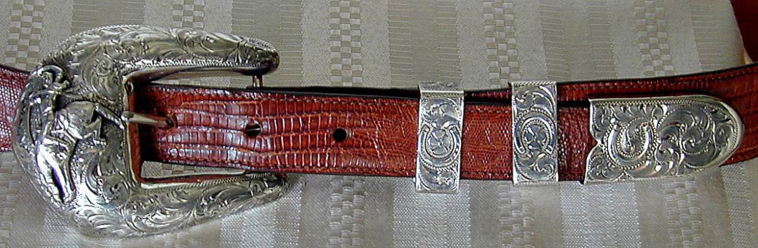 VINTAGE A. HYKES WESTERN STERLING 4PC BUCKLE SET ON: VINTAGE A. HYKES WESTERN STERLING 4PC BUCKLE SET ON LIZARD BELT A rare and heavy gauge silver Western style sterling silver 4 piece buckle set designed by A. HYKES mounted on the original lizard skin