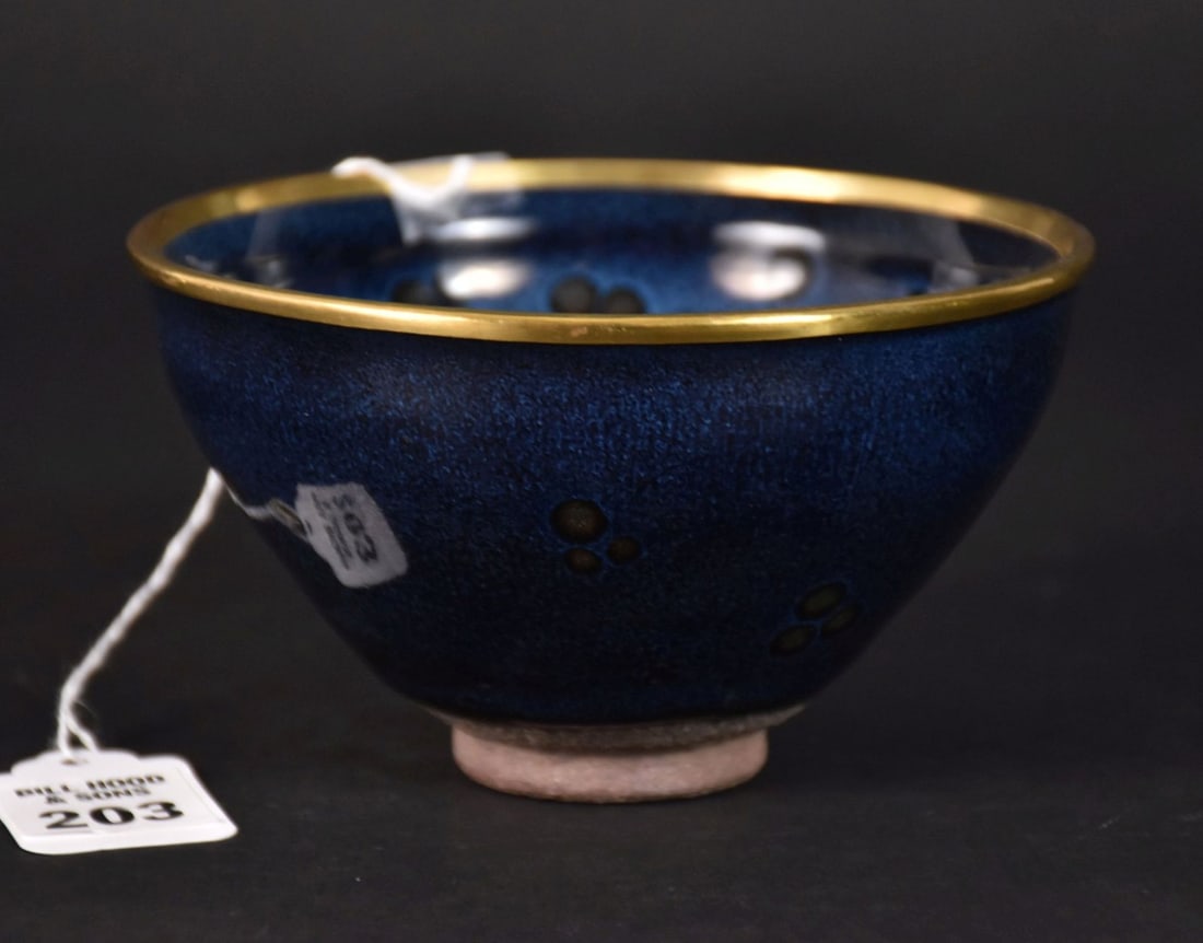 Chinese Jianyao Blue Oil Spot Tea Bowl - A deep, rounded conical bowl with an indented rim, covered: Chinese Jianyao Blue Oil Spot Tea Bowl - A deep, rounded conical bowl with an indented rim, covered in a lustrous light blue over black glaze, suffused with a pattern of russet streaked 'oil spots" th