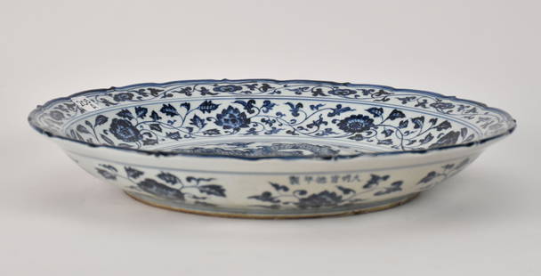 Large Chinese Blue & White Dragon Motif Charger, Xuande Mark - A large porcelain charger bowl with a: Large Chinese Blue & White Dragon Motif Charger, Xuande Mark - A large porcelain charger bowl with a central dragon motif in underglaze blue bordered by foliate scrolls and florals. Scalloped rim. Six