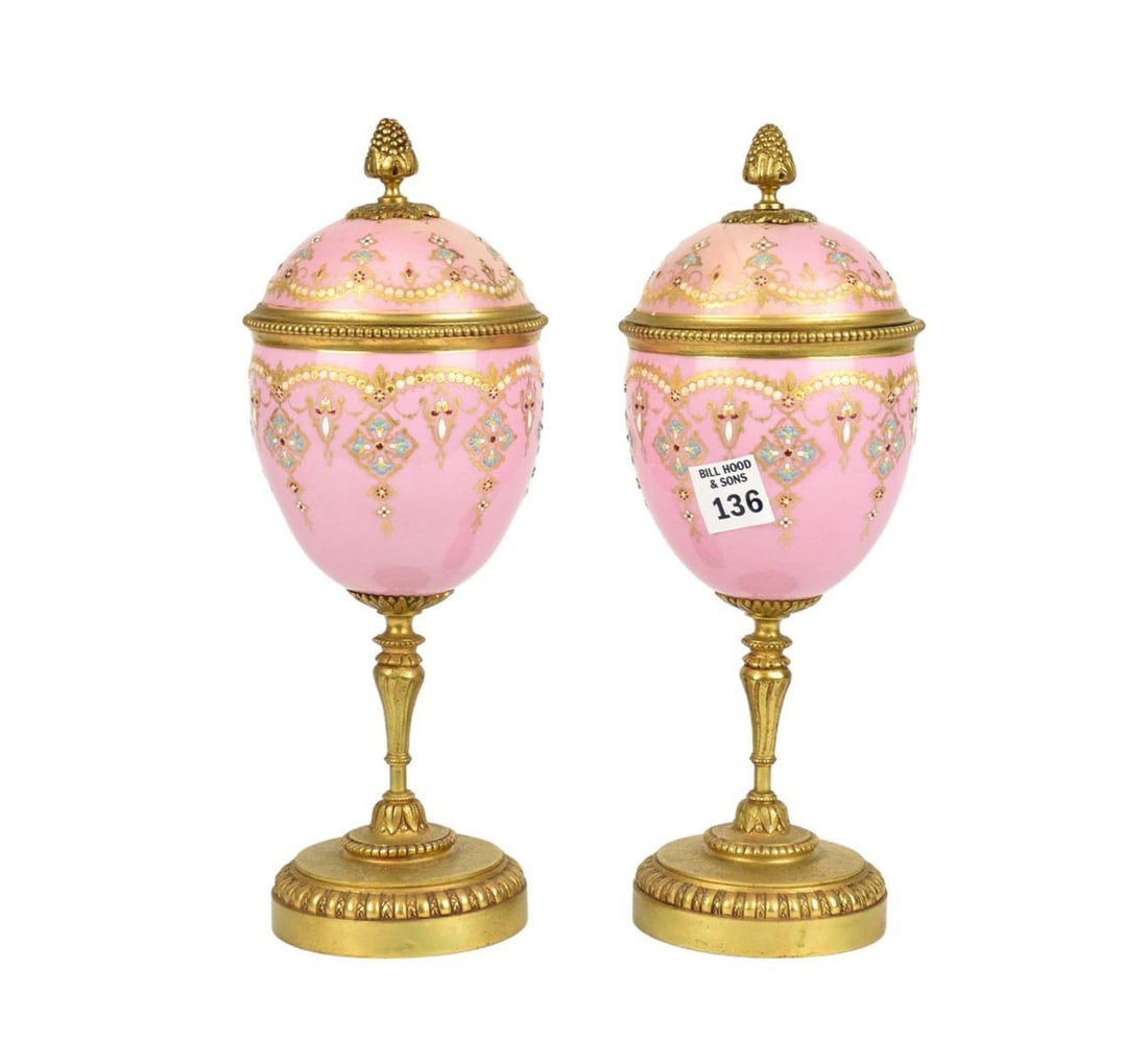 Pair of egg-shaped enameled vases with covers, mounted on a brass stand. The rose enameled ground: Pair of egg-shaped enameled vases with covers, mounted on a brass stand. The rose enameled ground decorated with polychrome “jeweled” enameling in imitation of 18th century Sèvres porcelain. 