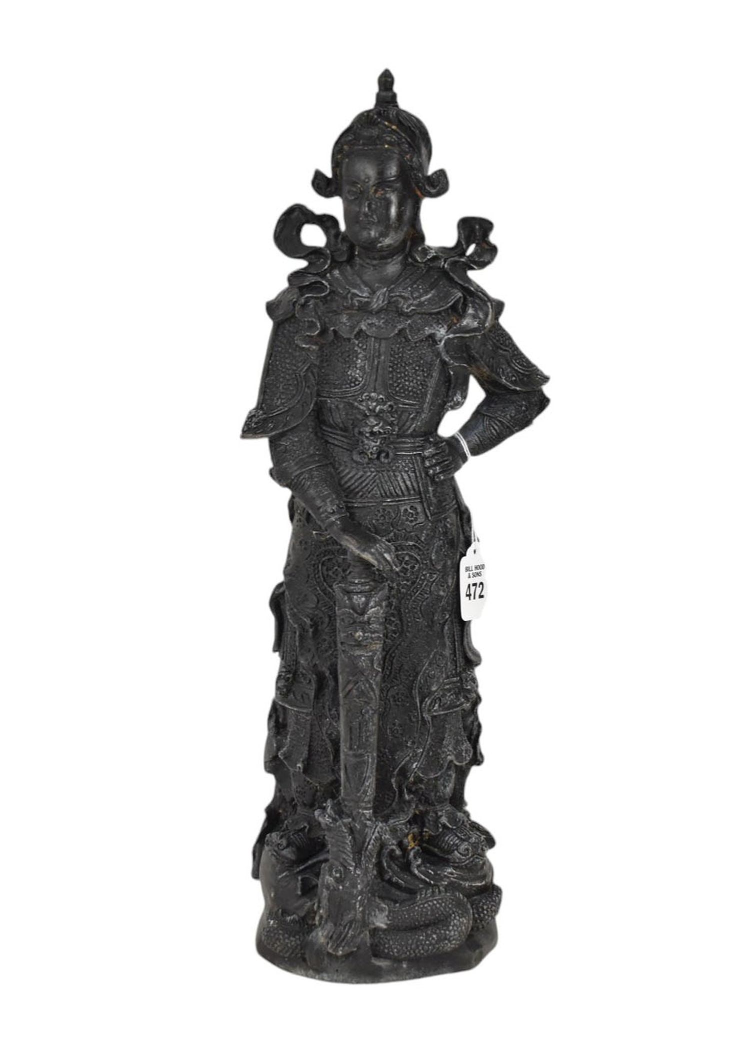 Chinese Bronze Figure of a Mythical Warrior - A cast bronze figure of a warrior with elaborate: Chinese Bronze Figure of a Mythical Warrior - A cast bronze figure of a warrior with elaborate armor, depicted standing with the end of his sword in the mouth of a dragon at his feet. Black patination