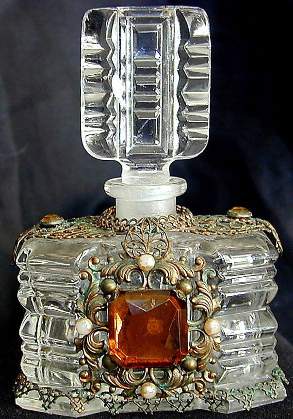 VINTAGE JEWELED CZECH PERFUME BOTTLE A vintage Cz: VINTAGE JEWELED CZECH PERFUME BOTTLE A vintage Czech perfume bottle with gilt filigree metal design and colored glass stones; 4.25"H; signed on the bottom Made In Czechoslovakia; good condition.