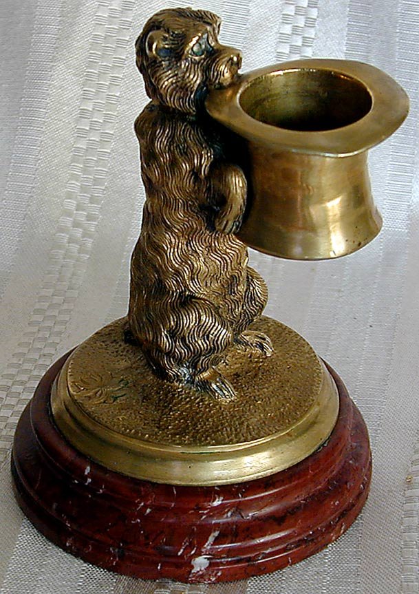 ANTIQUE BRONZE TERRIER MATCH HOLDER This is a cha: ANTIQUE BRONZE TERRIER MATCH HOLDER This is a charming 19thc bronze match holder depicting a terrier on his hind legs holding a top hat; 4.5"H on a red marble base, very good condition.