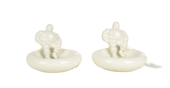 Two Bibendum Michelin Man Ashtrays, C. 1930s, white glazed ceramic, 3 3/4" h x 5" w. Condition: some