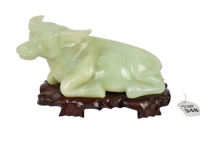 Chinese Jade Figure of a Recumbent Bull - A light green mottled semi-opaque carved jade figure of a
