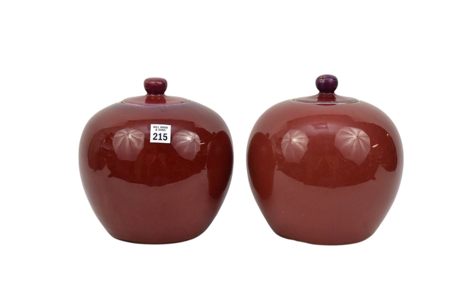 Two Chinese Sang de Boeuf Porcelain Jars - A pair of globular porcelain covered jars. Each of: Two Chinese Sang de Boeuf Porcelain Jars - A pair of globular porcelain covered jars. Each of similar melon-form shape, shape but with slightly different coloring of a flambe sang de boeff 'oxblood' g