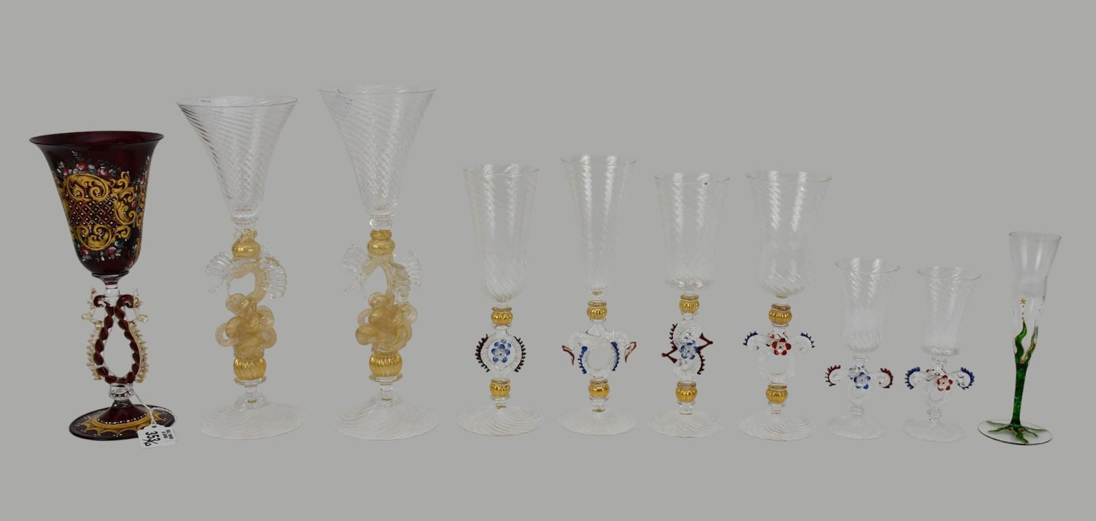 10 Hand Blown Assorted Venetian Wine Stems, (6) Red & Blue Intertwined Design, (1) Ruby Red with: 10 Hand Blown Assorted Venetian Wine Stems, (6) Red & Blue Intertwined Design, (1) Ruby Red with Armorial Enameling Design and (2) With Gilded Stems & Flying Fish, Tallest 11"h
