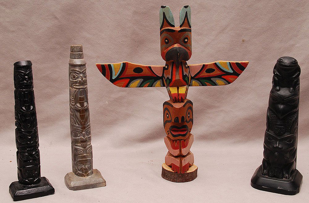Set of 4 Northwest Totem Poles. One cedar, inscribed on: Set of 4 Northwest Totem Poles. One cedar, inscribed on back: Made by Chief White Eagle, one by Boma, & two out of slate. Average sizes from 8" to 11" height.