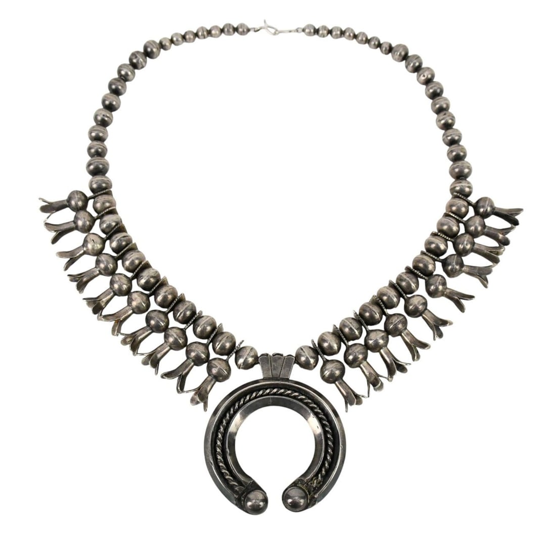 Navajo Silver Squash Blossom Necklace by LBD, 20th Century, Having a crescent naja with rope and: Navajo Silver Squash Blossom Necklace by LBD, 20th Century, Having a crescent naja with rope and ball motifs, surmounted by a floral hook. The necklace composted of 20 fluted elongated petal beads int