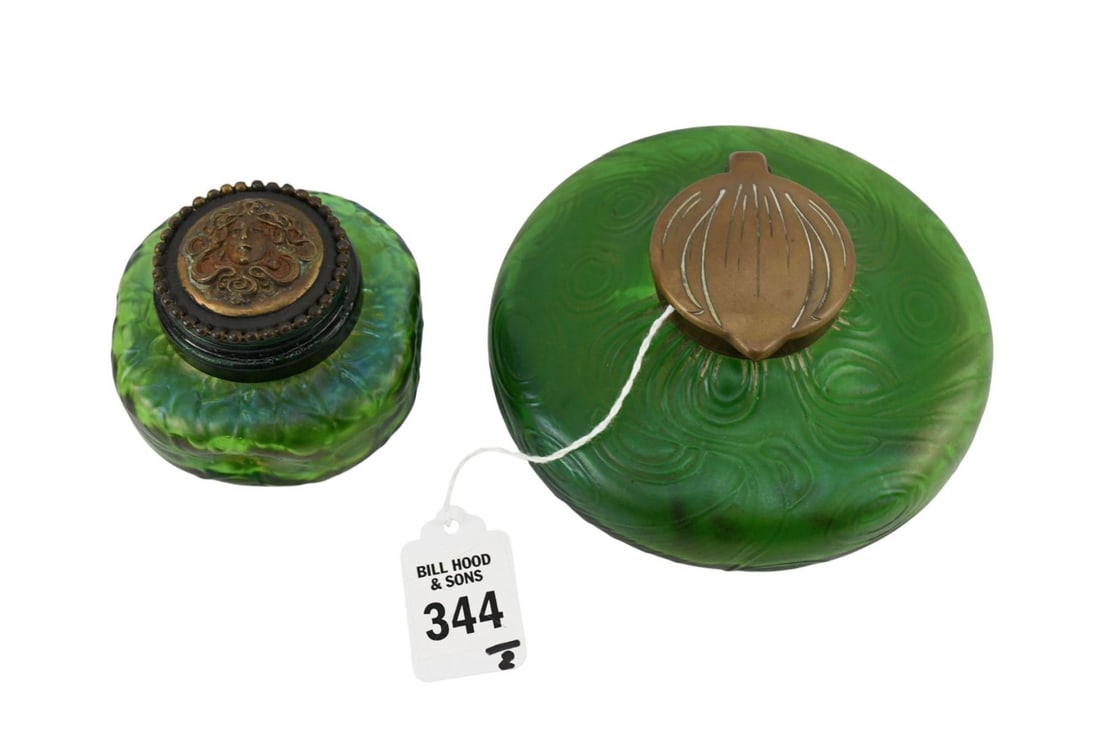 Two Art Nouveau Bohemian Iridescent Glass Inkwells - Austria, C. 1900. Loetz, Kralik. Both with: Two Art Nouveau Bohemian Iridescent Glass Inkwells - Austria, C. 1900. Loetz, Kralik. Both with green iridescent glass bodies. Comprising: A) A Kralik inkwell, brass hinge lid, 5 1/4" dia. B) A Loetz