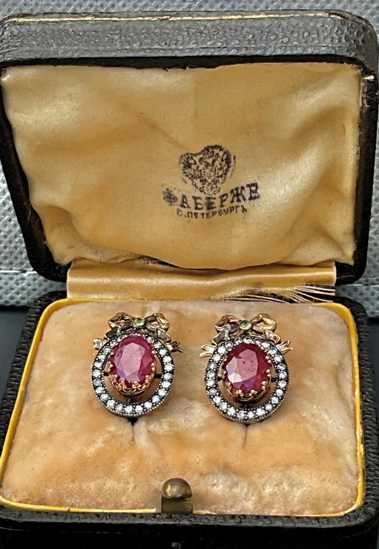 Russian 14k Gold Diamond & Ruby Bow earrings: Imperial Era Russian 14k Gold Diamond & Ruby Bow EarringsPair of 14k Russian Fabergé-era earrings, each centered by an oval ruby weighing approximately 5 carats in total bezel-set within an oval halo