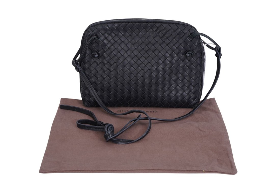 Bottega Veneta Black Crossbody featuring the signature Intrecciato woven design with a long: Bottega Veneta Black Crossbody featuring the signature Intrecciato woven design with a long adjustable slim crossbody strap. Made of exceptionally soft Nappa lambskin. Dual zip top closure. Bag has be