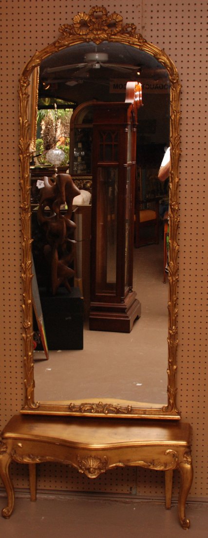 Gilded pier mirror over small table, bow motif, 68" x 2: Gilded pier mirror over small table, bow motif, 68" x 27"w