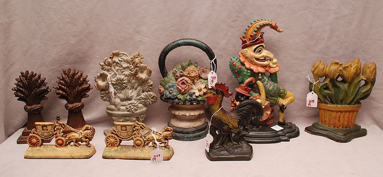 9 assorted iron door stops, incl; floral (8"h), pair pa: 9 assorted iron door stops, incl; floral (8"h), pair palm trees (7 1/2"h), pair carriages (6 1/2"h), clown (12"h), floral (9 1/2"h), flower basket (10"h) and rooster (7"h)